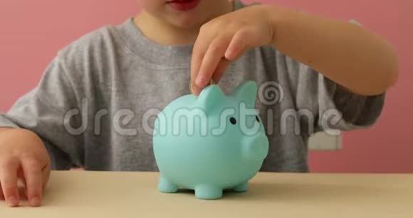 小男孩把硬币放进储蓄罐里视频的预览图