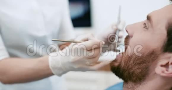 女牙医在她的病人牙齿上工作视频的预览图