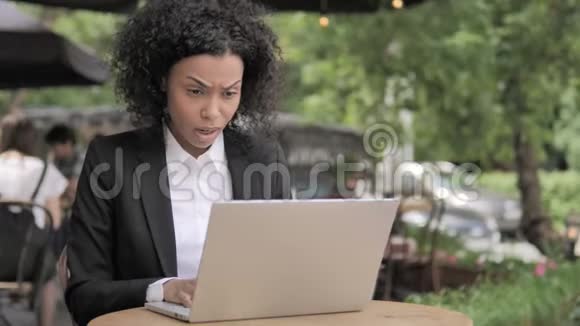 非洲妇女坐在室外咖啡厅失声痛哭视频的预览图