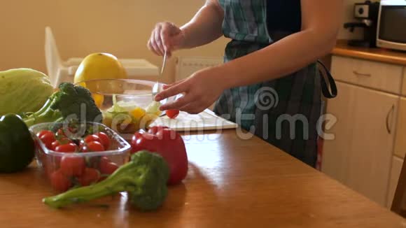 无法辨认的女人把蔬菜沙拉混合在透明的碗里厨房里的女人适当的营养视频的预览图