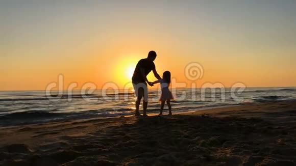 慢动作快乐的家庭时光父亲和女儿在日出时旋转视频的预览图