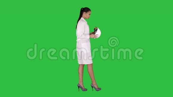 穿白色长袍的女人戴着安全帽走在绿色的屏幕上Chroma键视频的预览图
