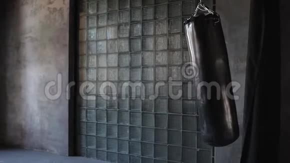 暗日的健身房拳袋摆动从踢没有人视频的预览图