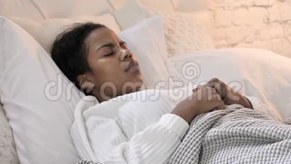 生病的非洲青年妇女在床上咳嗽视频的预览图