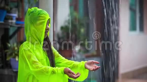 一个穿雨衣的女孩收集雨水视频的预览图