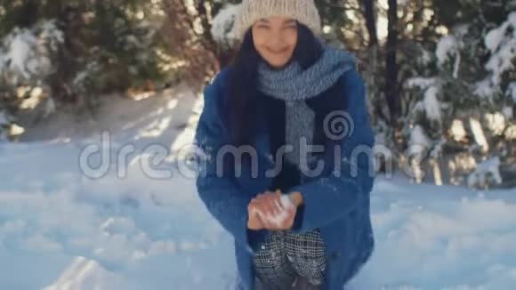 女人扔雪球打相机慢动作4K高质量的锐利镜头视频的预览图