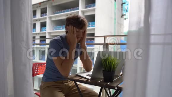一个年轻人拿着笔记本坐在阳台上被一个人发出的一声巨响所伤视频的预览图