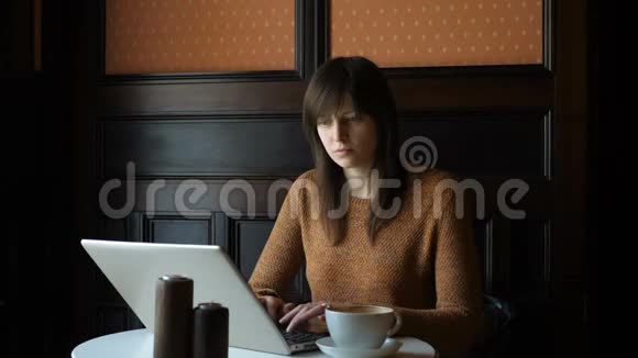 有笔记本电脑的咖啡厅的女孩视频的预览图
