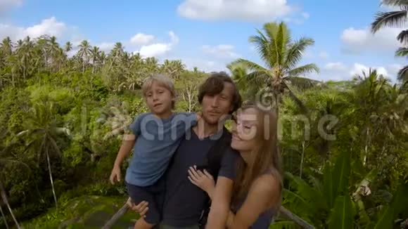一个年轻的家庭在一个大平台上拍摄自拍可以看到丛林视频的预览图