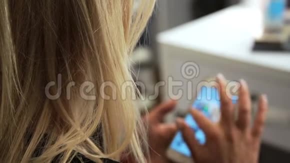 金发美女坐在网上的手机冲浪视频的预览图