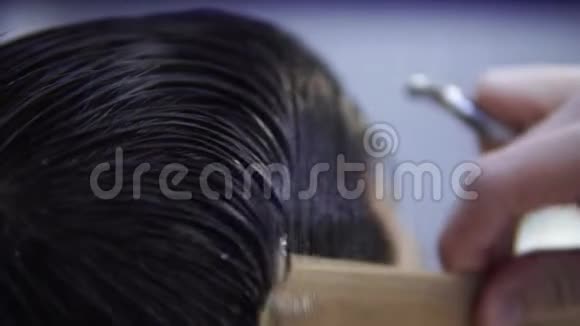 理发店的顾客用刷子特写梳湿头发视频的预览图