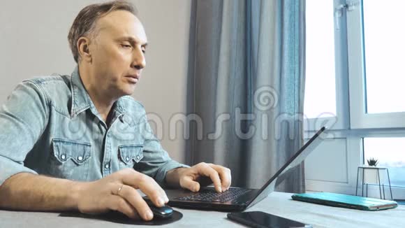 他在家里用笔记本电脑工作从底部看视频的预览图