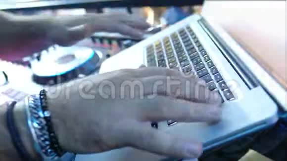 DJ的手在笔记本电脑后面工作4K视频的预览图