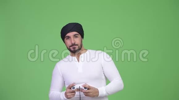 年轻的有胡子的印度男人在玩游戏视频的预览图