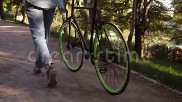 在早晨的公园或街道上除了一辆自行车还有一个穿着运动鞋的女人走路的镜头少见的年轻人视频的预览图