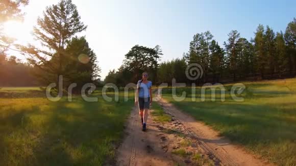 日落时分在乡间小路上散步的女孩视频的预览图