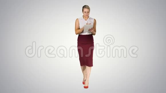年轻的职业女性使用平板电脑并步行到相机梯度背景视频的预览图