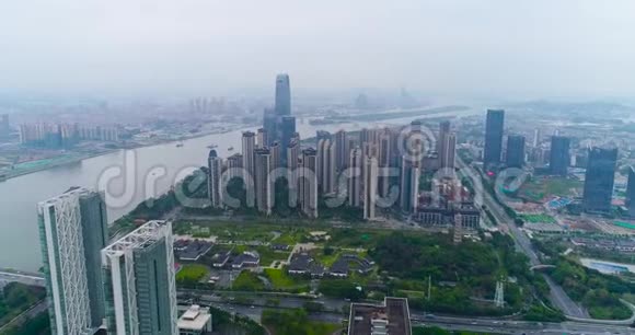 乘坐无人机飞越中国大城市瓜州上空飞越江边的高楼大厦视频的预览图