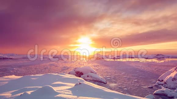 明亮的太阳升起在橙色的天空下反射着冰冻的水视频的预览图