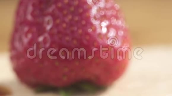 在果皮上有大种子的多汁成熟红草莓的宏观摄影视频的预览图