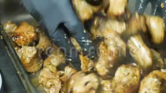 厨师的手搅动白肉和红肉的烤肉串放在刚从火里取出的一个大铁盘里视频的预览图