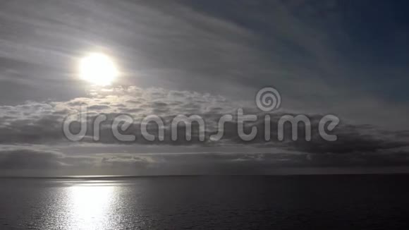 在一个多云的傍晚逆着太阳在海洋上空飞行视频的预览图