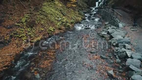 泡沫瀑布从岩石山落下来沿着小径流动视频的预览图