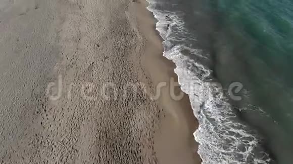 海浪和泡沫迅速飞过海浪撞击着沙滩视频的预览图