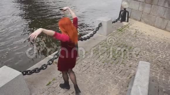 穿红裙子的女孩在水边跳舞视频的预览图