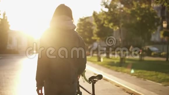 在城市道路上骑自行车的女人女自行车骑手在城市街道上行走特写概述镜头视频的预览图