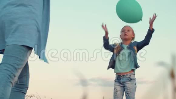 快乐的女儿和妈妈玩蓝色气球低角度视频的预览图