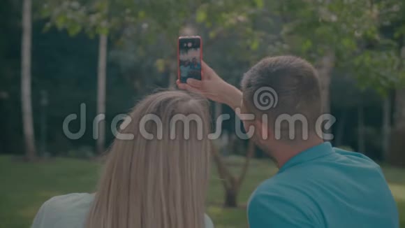 带手机的情侣在公园自拍视频的预览图
