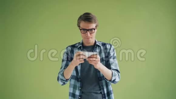 hipster在智能手机上玩游戏手持小工具触摸屏幕的画像视频的预览图