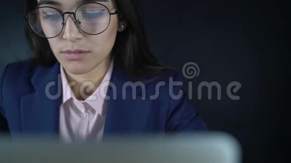 年轻漂亮的女商人拿着笔记本电脑坐在桌子旁晚上一个女性自由职业者远程工作视频的预览图