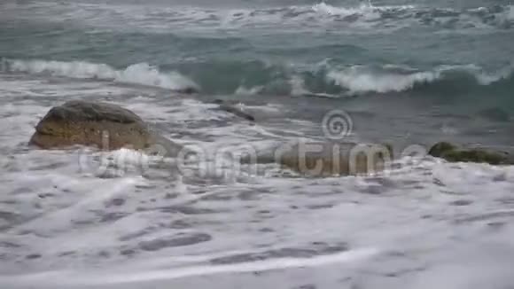 黑海的泡沫波聚集在克里米亚的诺维斯维村沙滩上的一块岩石上没有人视频的预览图