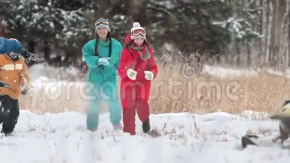 冬天幸福的家庭穿着五颜六色的衣服享受着玩雪的乐趣又跑又笑慢动作视频的预览图