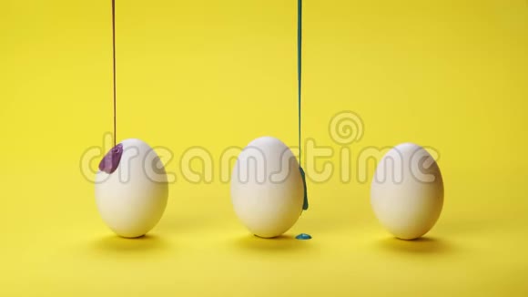 彩色颜料在三个鸡蛋上流动视频的预览图