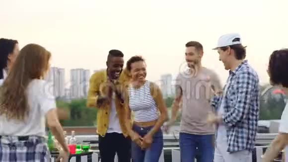 漂亮的混血女孩正在和朋友跳舞笑着享受屋顶派对娱乐户外聚会和视频的预览图