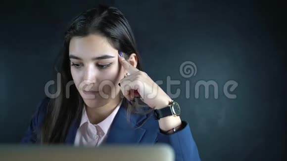 年轻漂亮的女商人拿着笔记本电脑坐在桌子旁晚上一个女性自由职业者远程工作视频的预览图