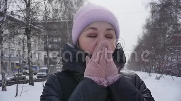 街上一位年轻女子的肖像她在冬天的公园里散步时双臂呼吸以保暖慢慢视频的预览图