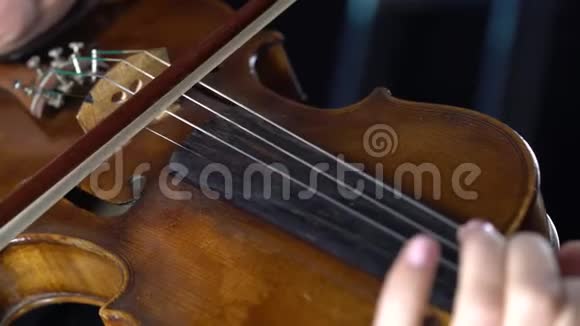 小提琴的特写指着琴弦和弓黑色背景视频的预览图