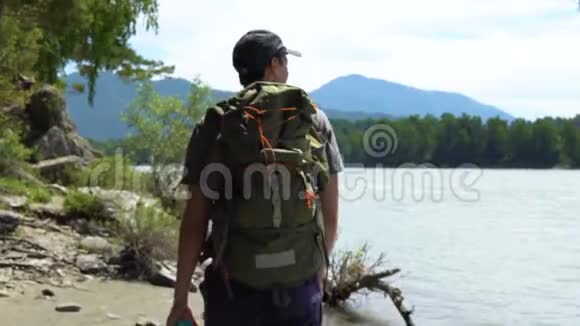 一位游客沿着一条山河的河岸散步视频的预览图