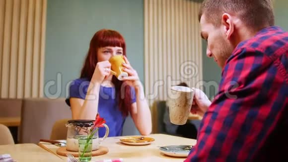 一对夫妇坐在一家咖啡馆的桌子旁喝茶视频的预览图