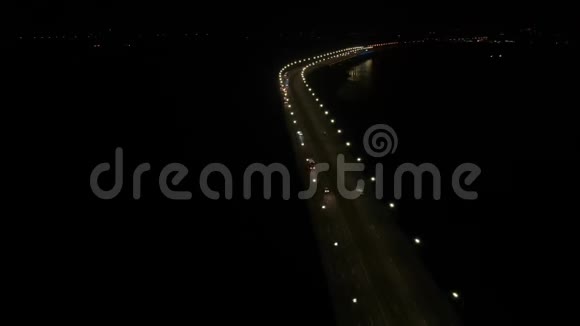 空中拍摄了一座长桥沿途有很多灯光交通在移动晚上水面反射4K视频的预览图