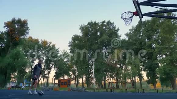 漂亮的金发女运动员投掷篮球圈球打圈早上在公园里玩耍视频的预览图