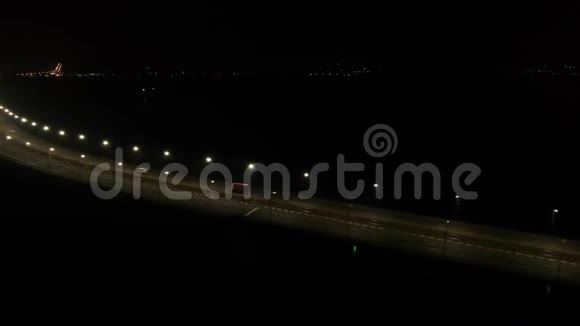 城市的明亮灯光在一座巨大的桥的背景下汽车在桥上移动视频的预览图