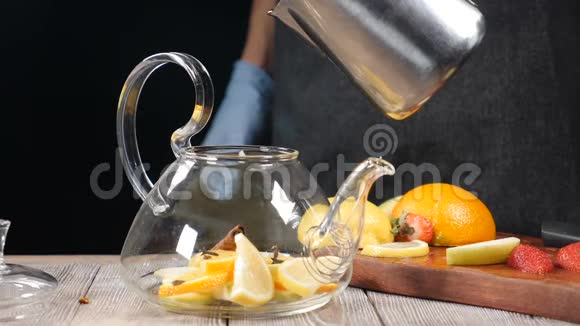 将热水倒入茶壶中放入切好的水果玻璃茶壶里面有橘子和柠檬茶的酿造慢动作热辣视频的预览图