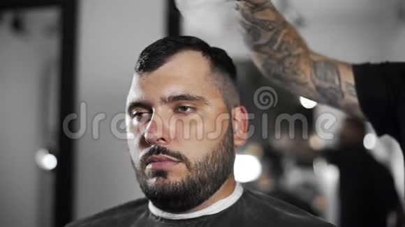 理发师用刷子把顾客肩膀上剪下来头发拂去理发师为顾客理发视频的预览图
