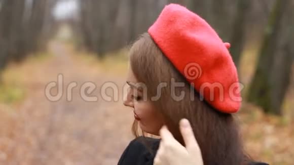 一位身穿红色贝雷帽红唇的美女的复古肖像她微笑着看着室外的镜头视频的预览图