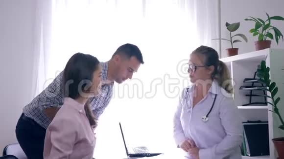 健康夫妇一起去看医生医生在医务处咨询一个年轻家庭的女性生育情况视频的预览图